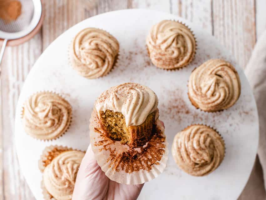 Premium Photo  Scooping pumpkin spice cupcake batter with batter scoop  into a cupcake pan with liners.