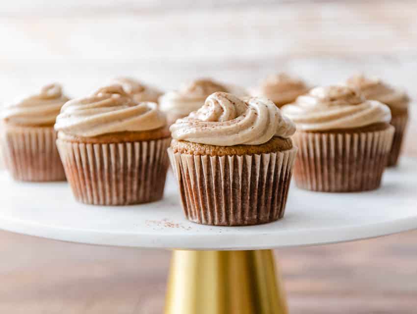 Premium Photo  Scooping pumpkin spice cupcake batter with batter scoop  into a cupcake pan with liners.